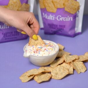 A hand scooping out high protein dunkaroo with a chip.
