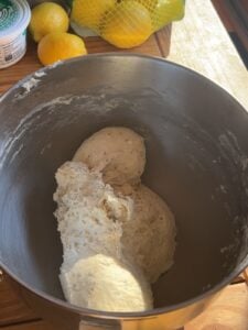 Kneaded dough in a metal bowl.
