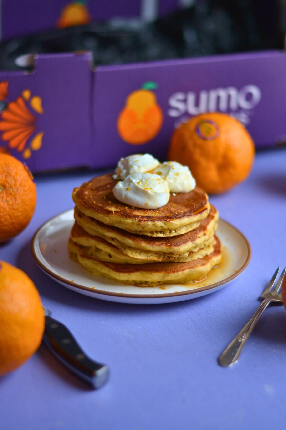 A stack of orange protein pancakes on a purple background.