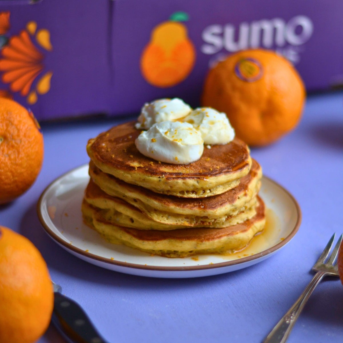 A stack of orange protein pancakes on a purple background.