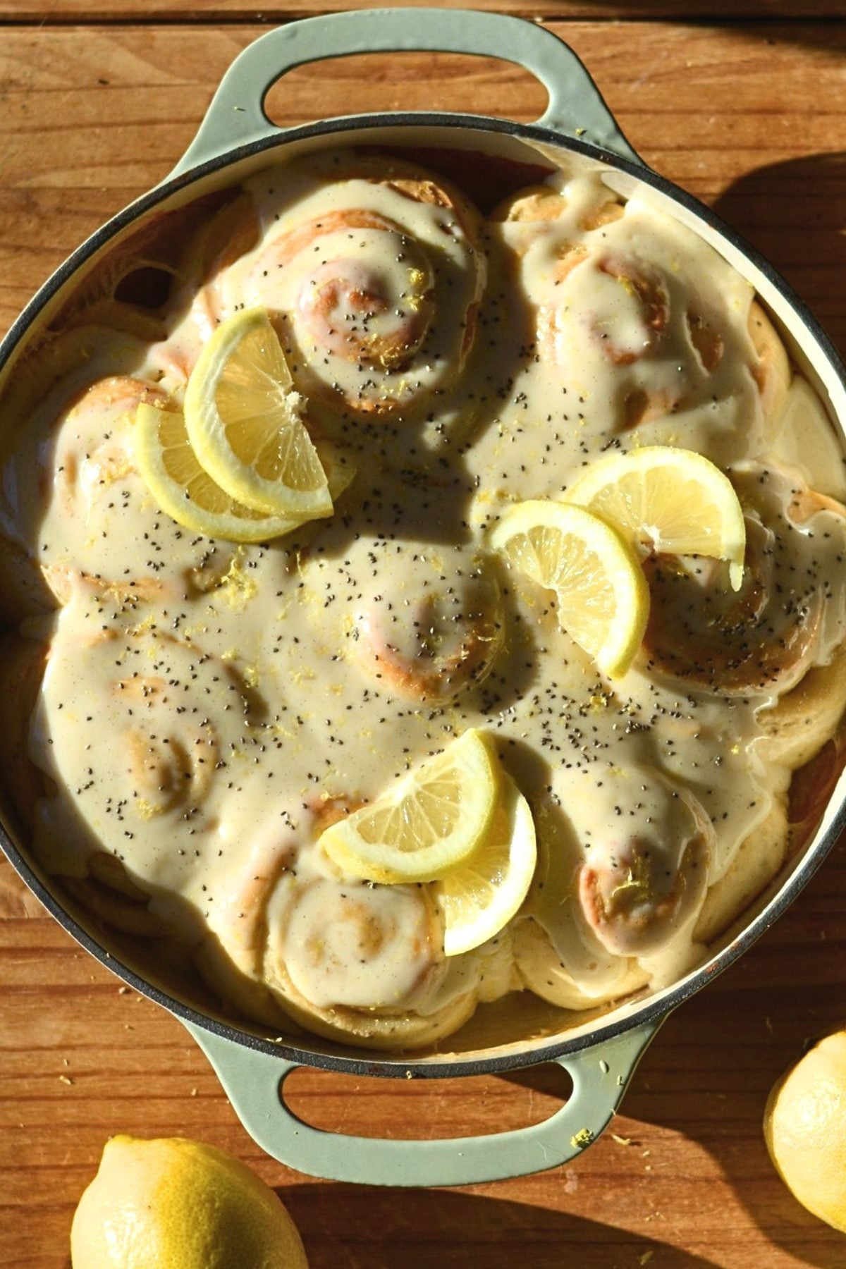 A round baking dish filled with frosted protein lemon rolls.