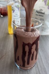 Pouring the tofu frappuccino into a cup.