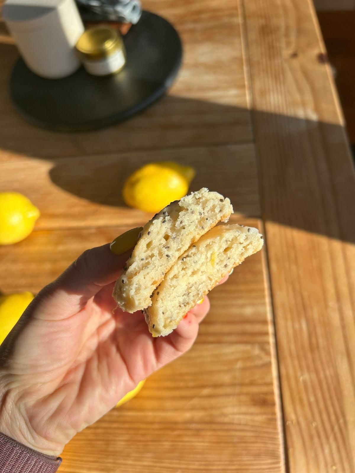 A hand holding two cottage cheese cookie halves to show the inside tender crumb.