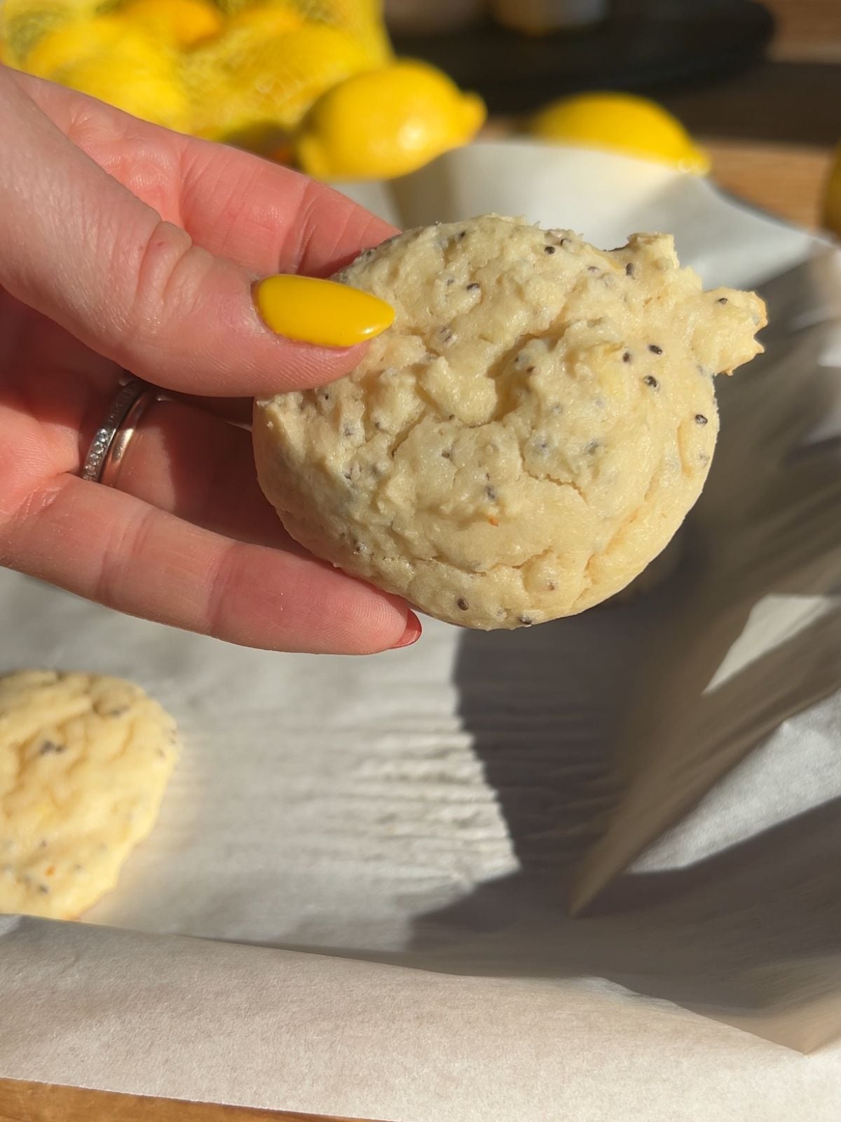 Hand holding a cottage cheese cookie right after baking and before glazing.