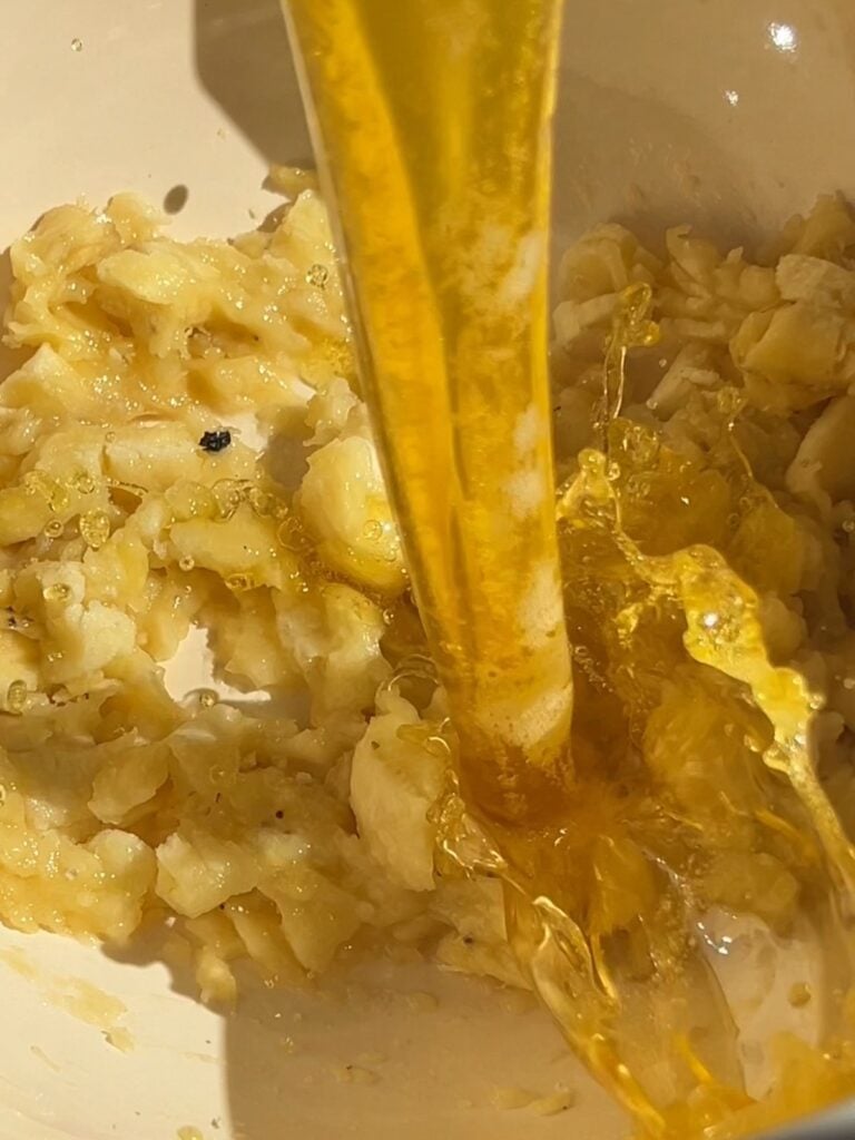 Pouring brown butter into the mashed bananas.