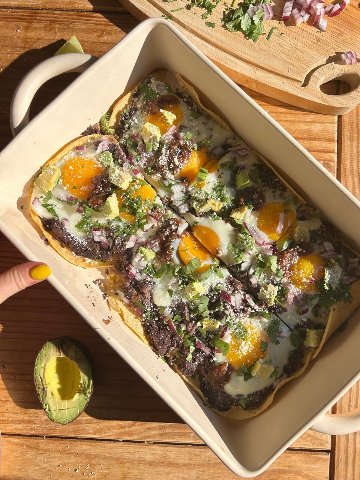 A pan of sheet paan huevos rancheros with toppings.