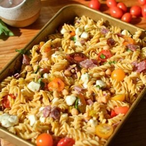 High-protein pasta salad with tomatoes, mozzarella pearls, salami, and chickpeas.