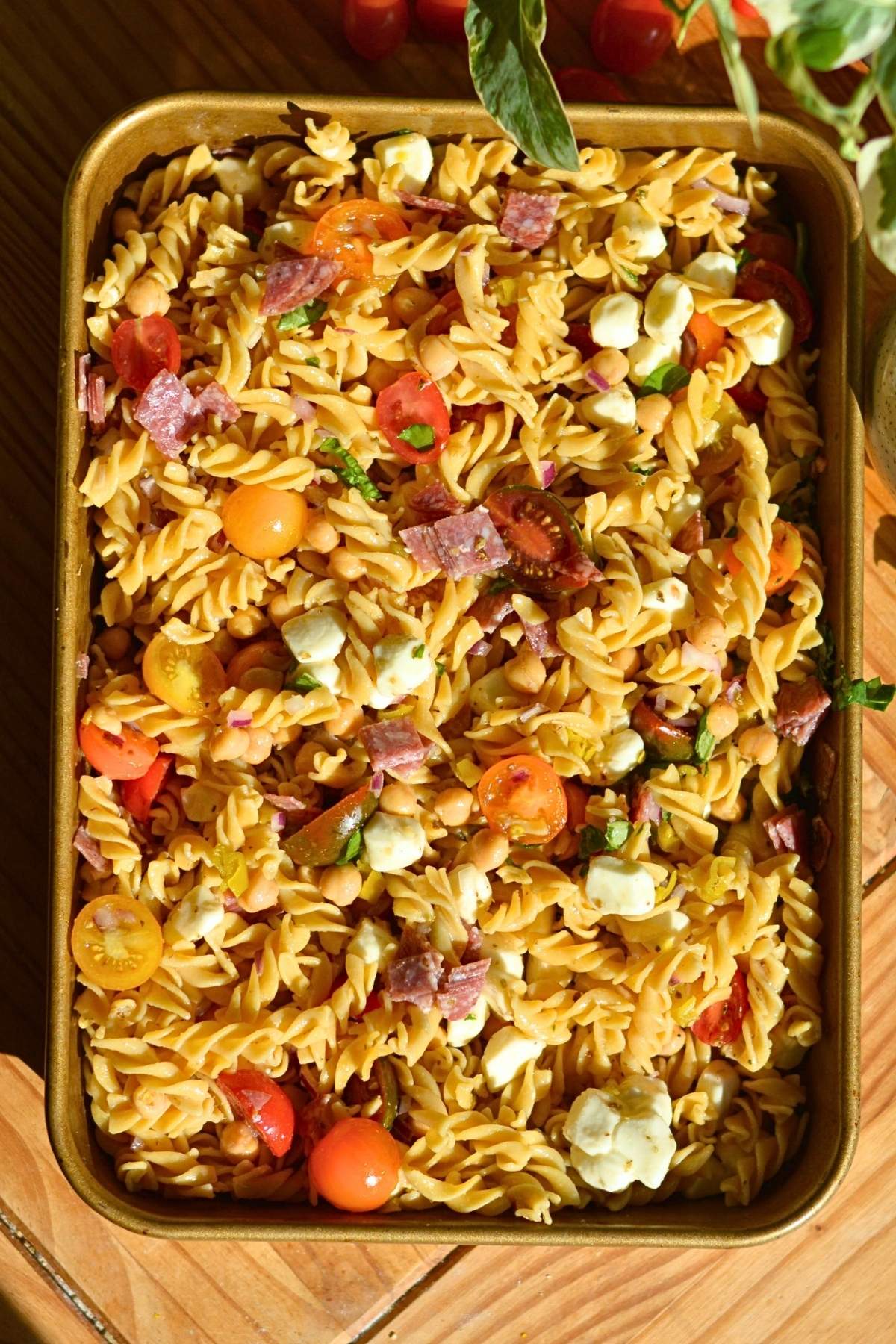 High-protein pasta salad with tomatoes, mozzarella pearls, salami, and chickpeas.