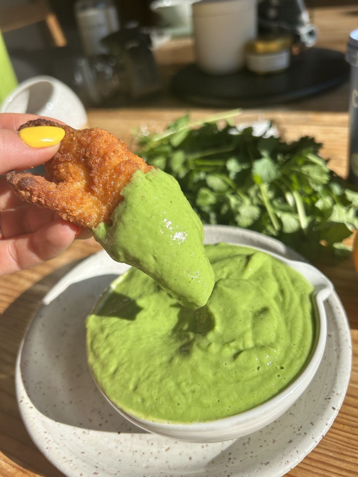 Dipping a chicken tender into the hi protein avocado sauce.