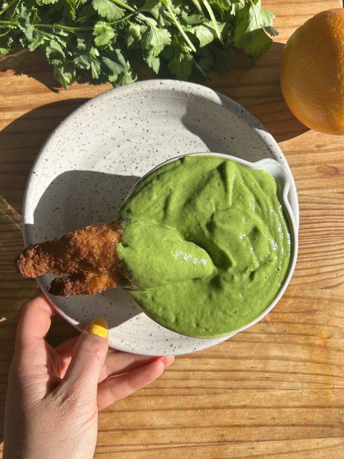 Dipping a chicken tender into the high protein avocado sauce.