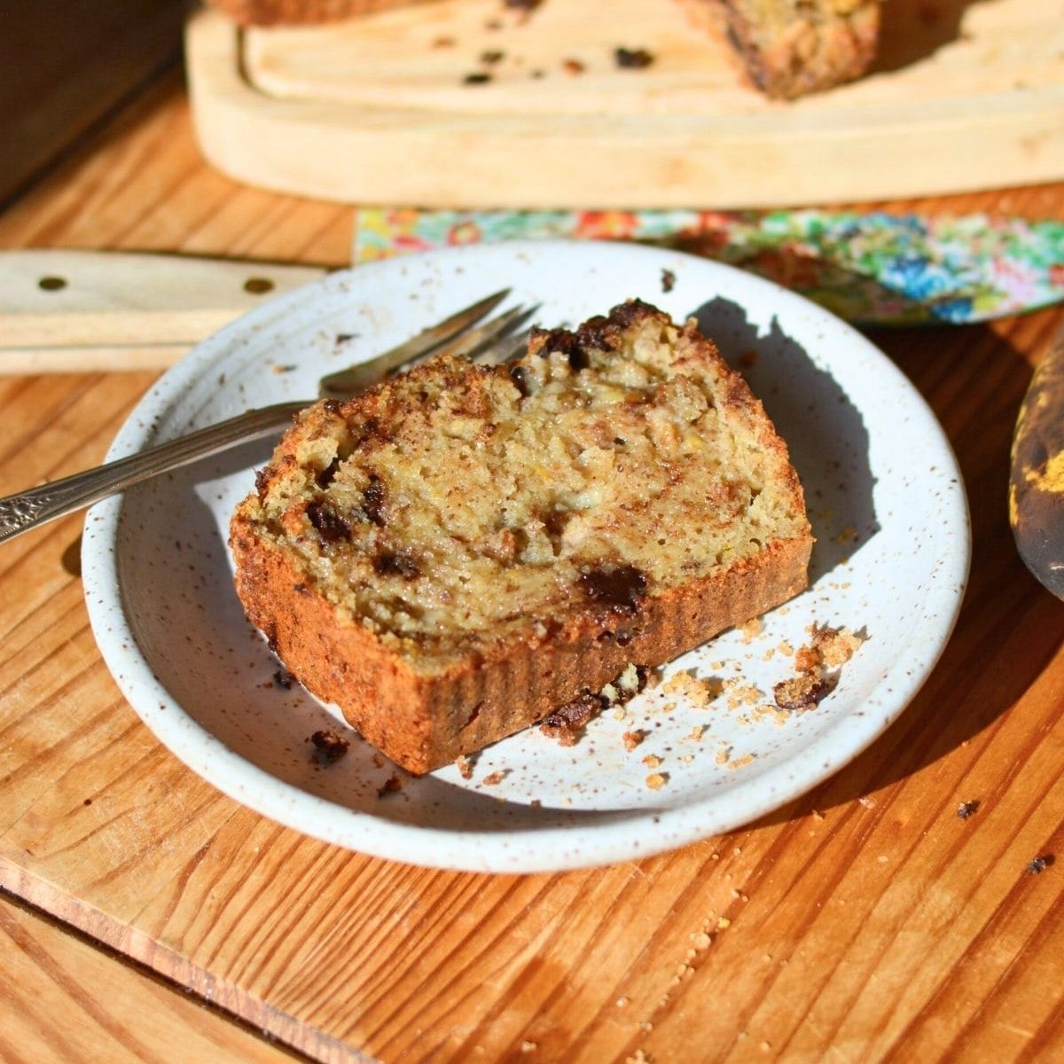 A slice of brown butter protein banana bread on a white plate.