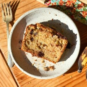 A slice of brown butter protein banana bread on a white plate.