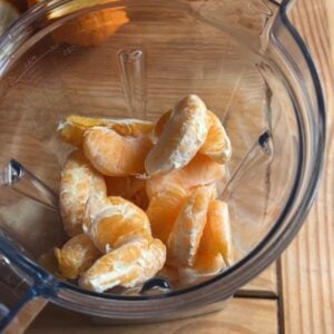 a blender with frozen orange slices.
