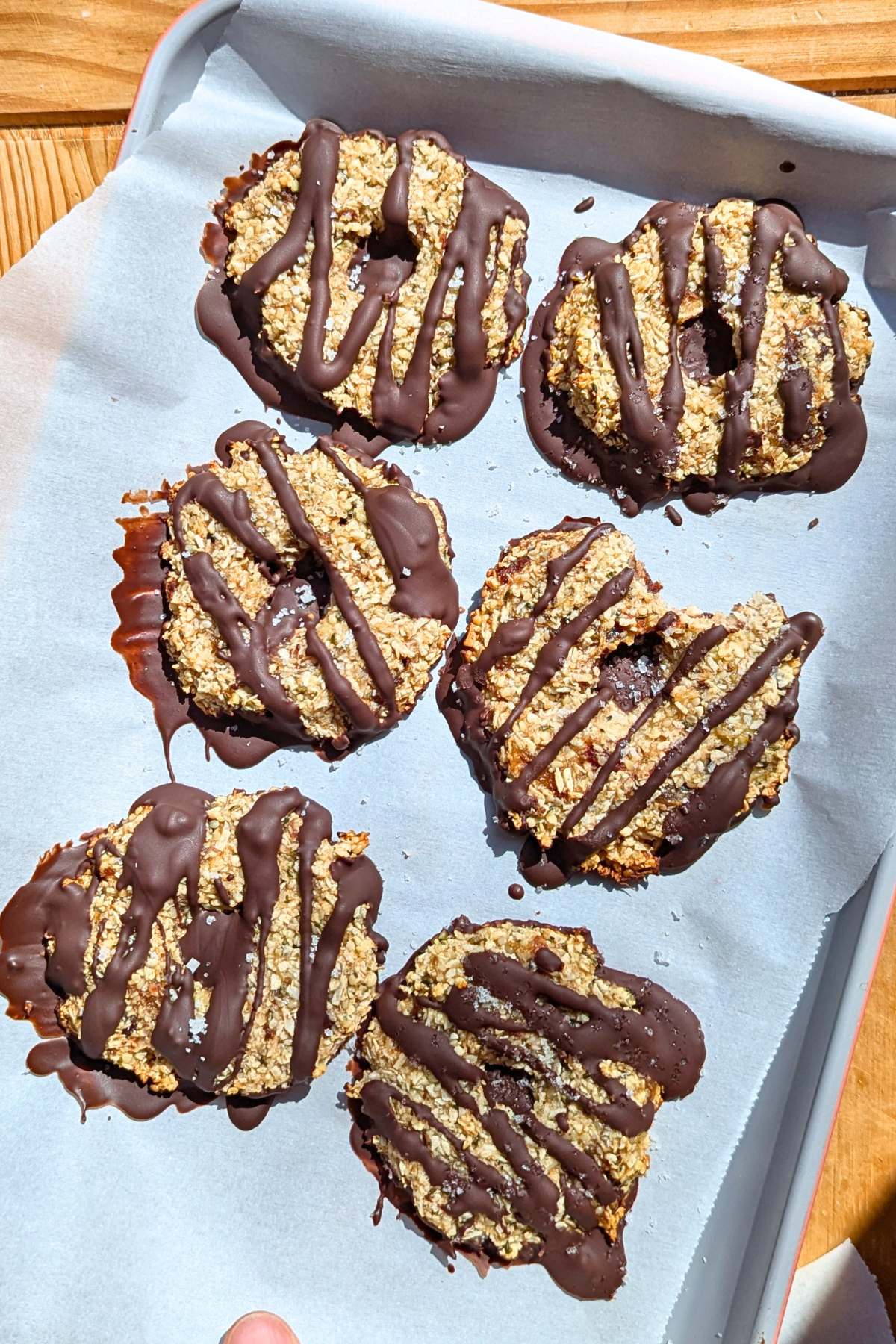 Healthy samoa cookies with chocolate drizzle on parchment paper.