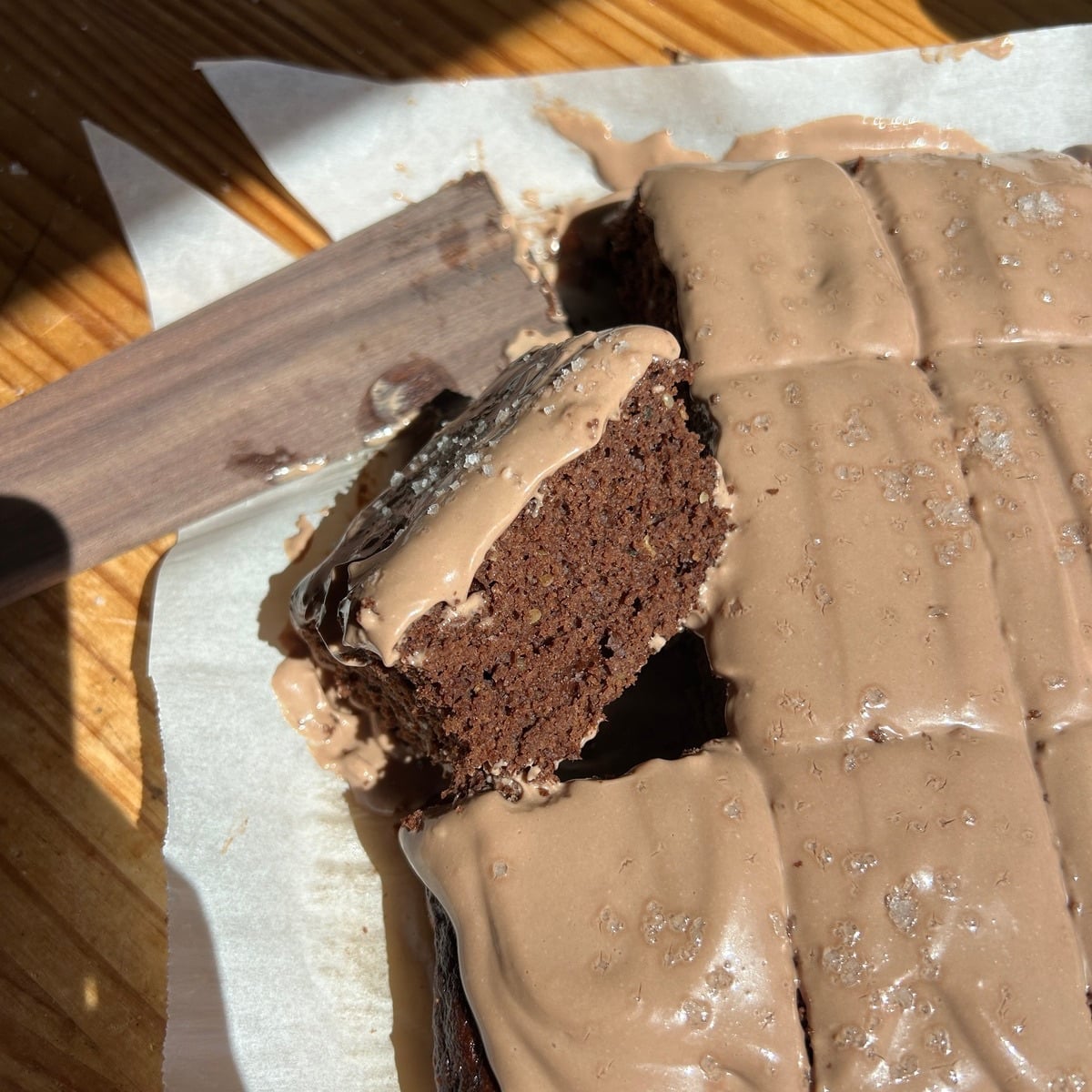 Chocolate cake slice piece leaned up on the cake.