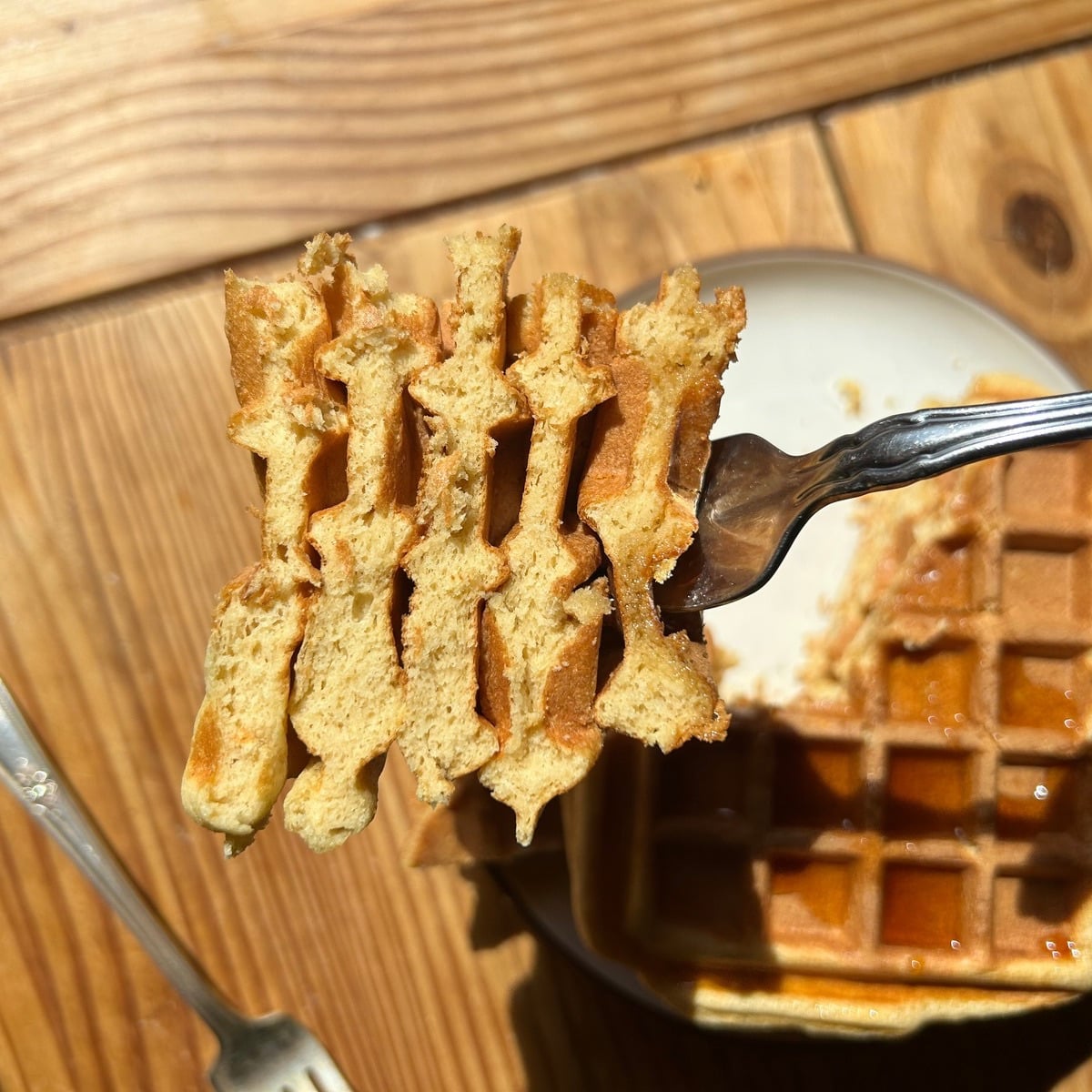 A fork holding cut up cottage cheese waffles.