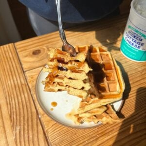 A fork holding cut up cottage cheese waffles.
