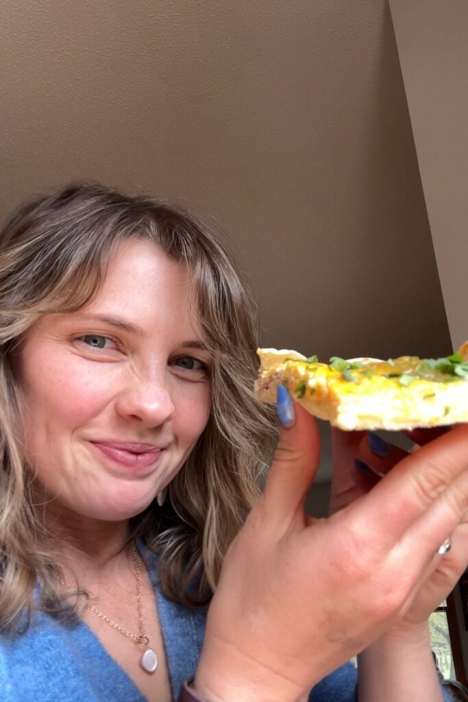 Mika holding a slice of the pizza.