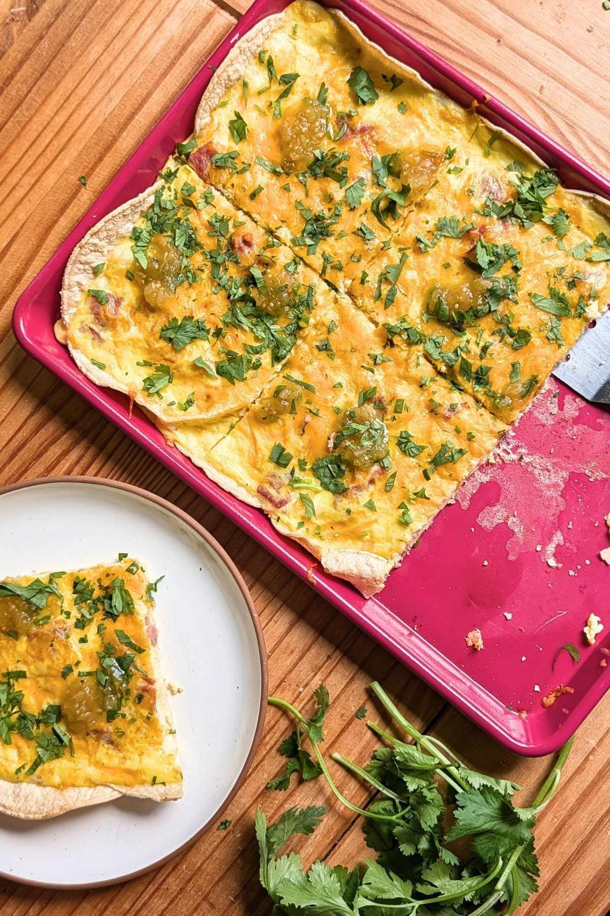 breakfast pizza on a pink sheet tray.