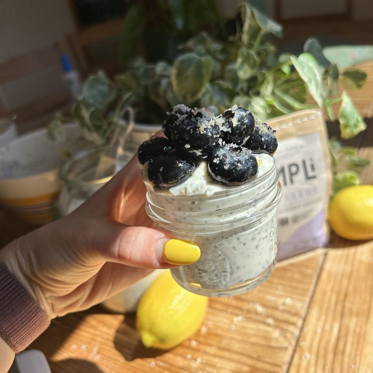 Hand holding chia seed pudding with greek yogurt.