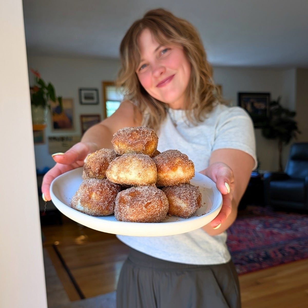 A pretty lady holding a plate of protein pretzel bites.