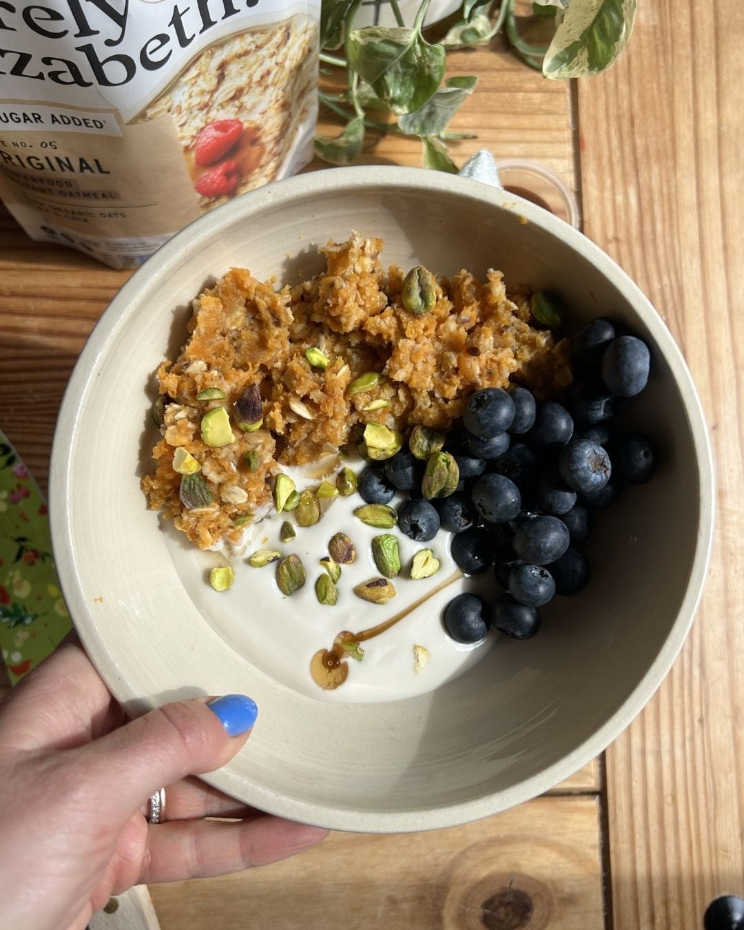 A bowl of yogurt, blueberries, and scrambled oats.