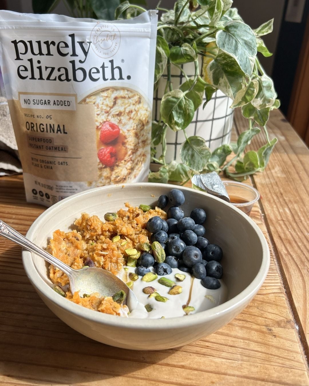 A bowl of yogurt, blueberries, and scrambled oats.