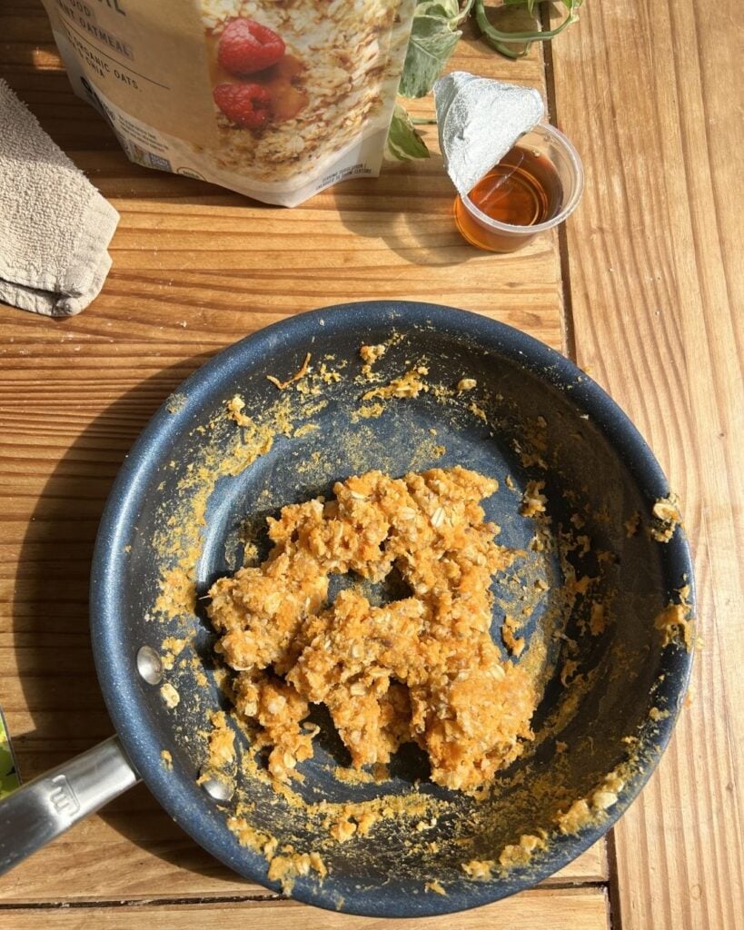 A skillet with cooked scrambled oats.