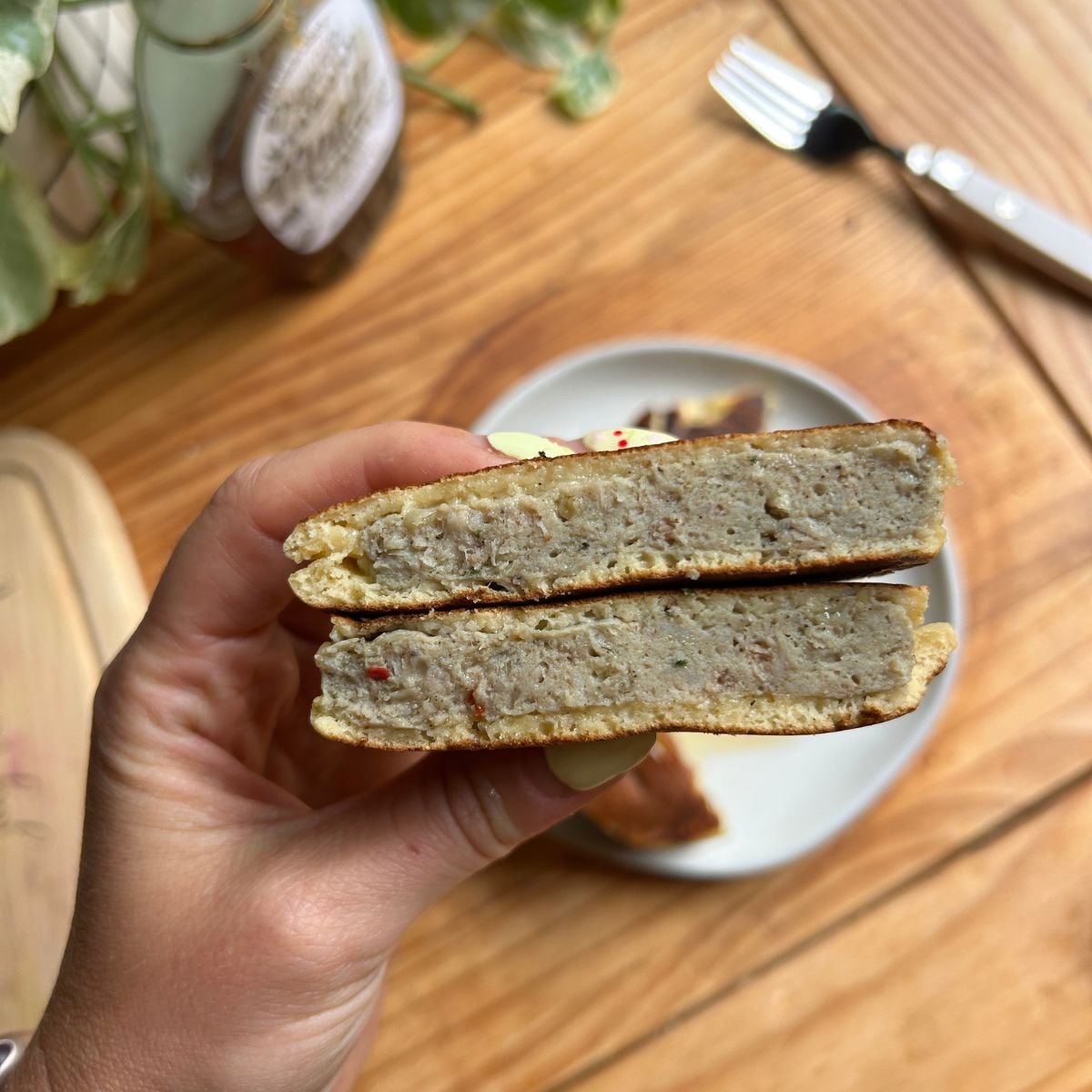 Hand holding cut open pancake sausage.