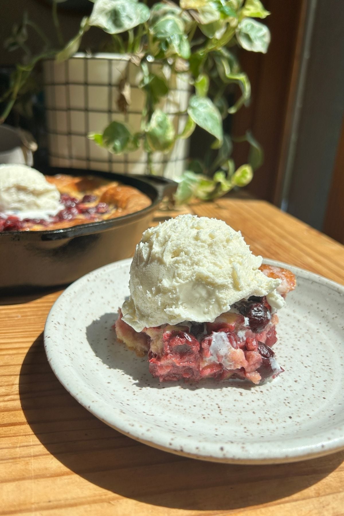 A plate with protein cherry cobbler and ice cream on it.