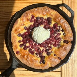 A cast iron with protein cherry cobbler in it.