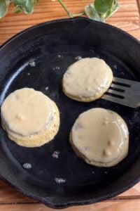 flipping pancake sausages on the cast iron.