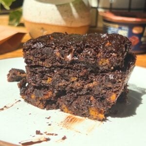A stack of protein chocolate brownies on a white plate.