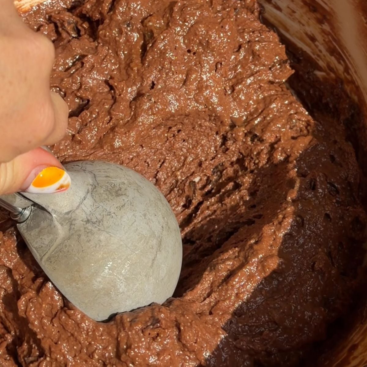 Scooping muffin batter.