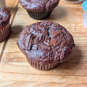 A chocolate chunk muffin on a table.