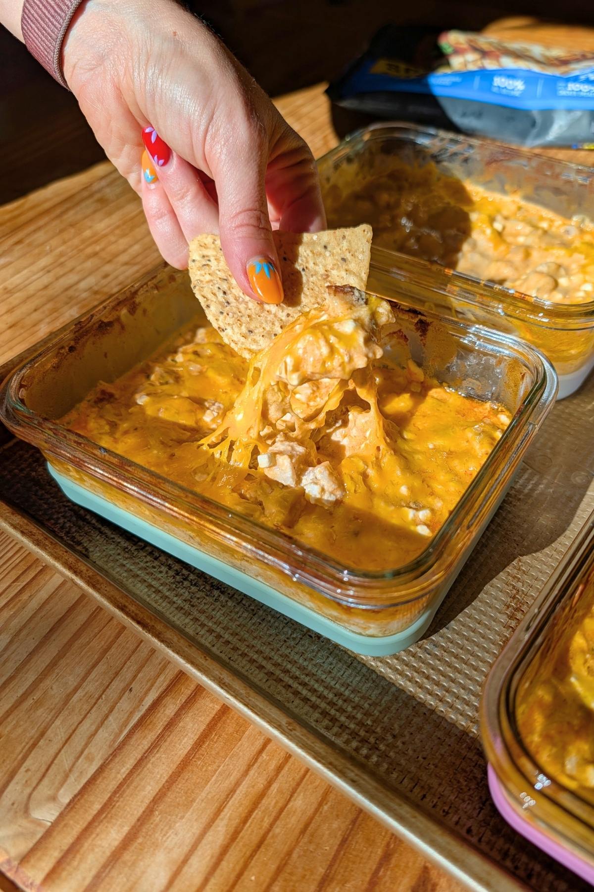 Buffalo chicken dip being pulled out of a container.
