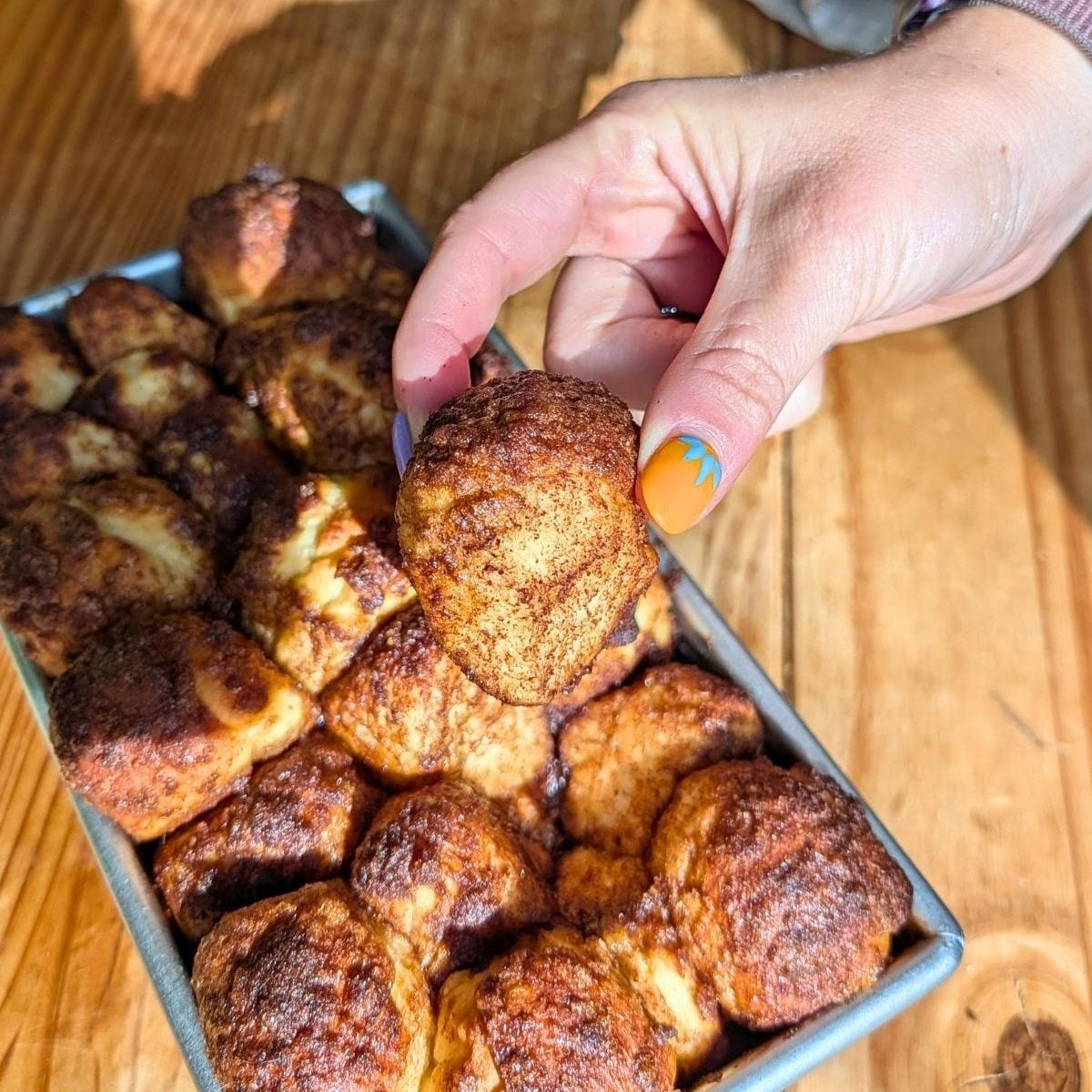 Hand holding single monkey bread piece.