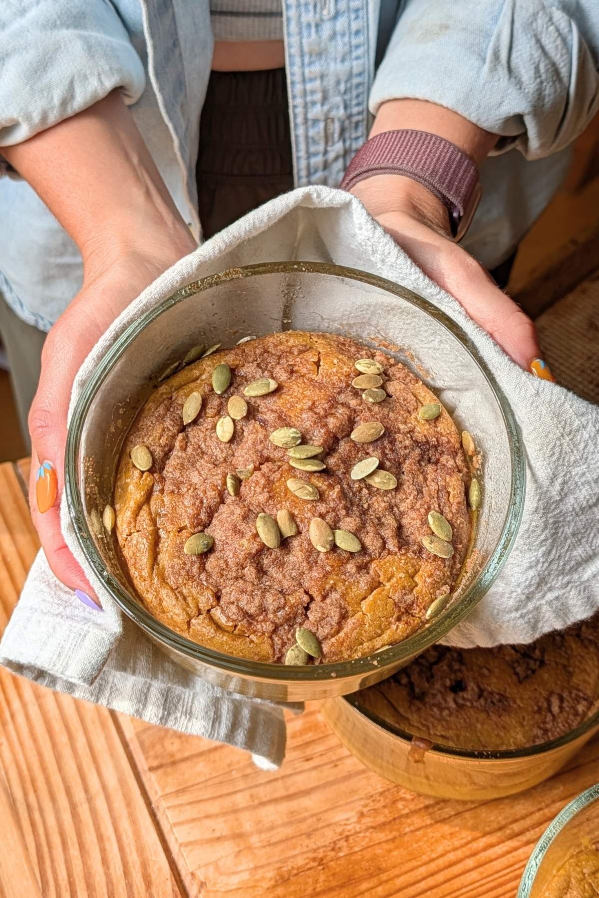 Hands holding pumpkin pancakes.