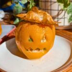 An orange bell pepper stuffed with chicken pot pie filling.