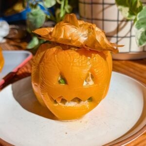 An orange bell pepper stuffed with chicken pot pie filling.