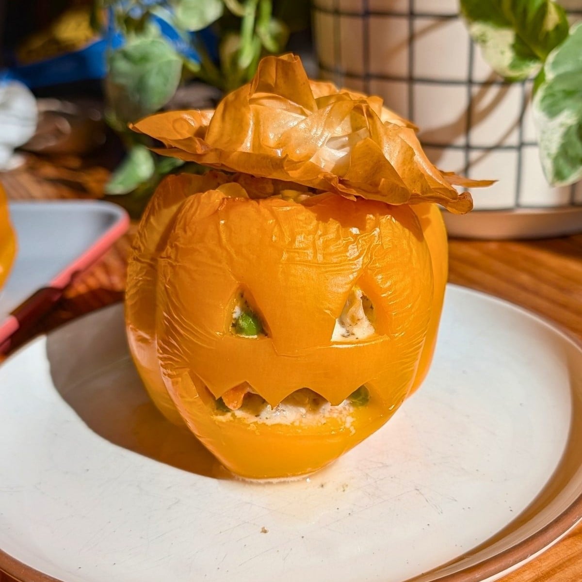 An orange bell pepper stuffed with chicken pot pie filling.